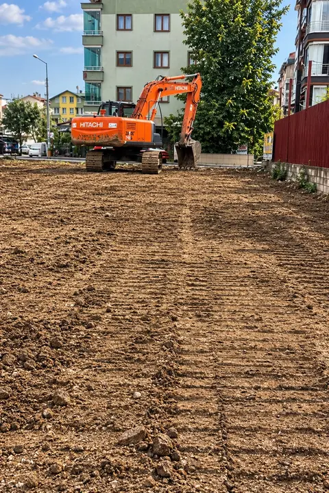 Tesviye edilmiş toprak zeminde çalışan turuncu ekskavatör
